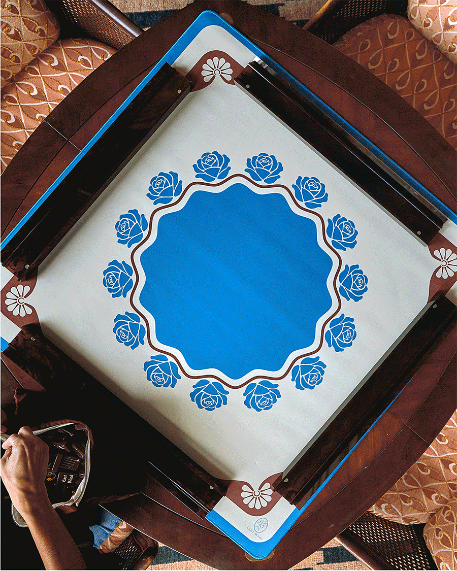 Briar mahjong mat with blue roses on a mahjong table, seen from above