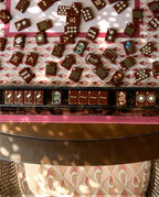 Mahjong tiles set out on a rack in front of the Currant mahjong mat