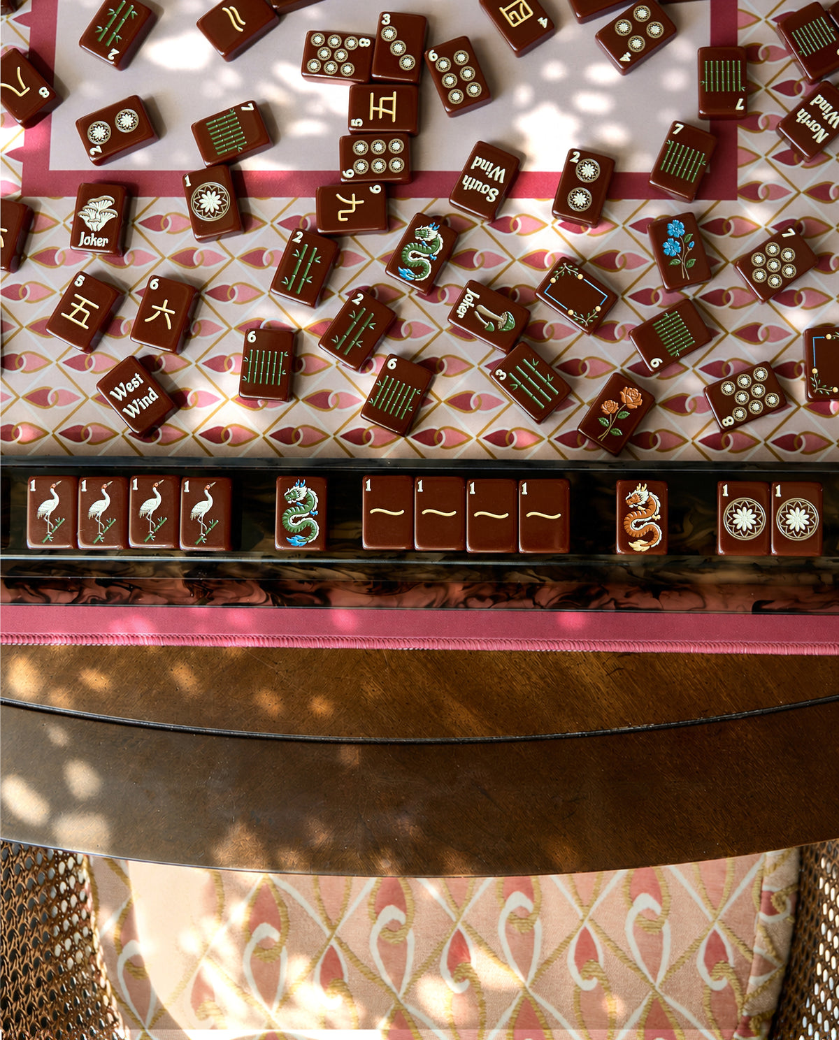 Mahjong tiles set out on a rack in front of the Currant mahjong mat