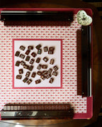 Currant mahjong mat on a mahjong table with tiles and racks, seen from above